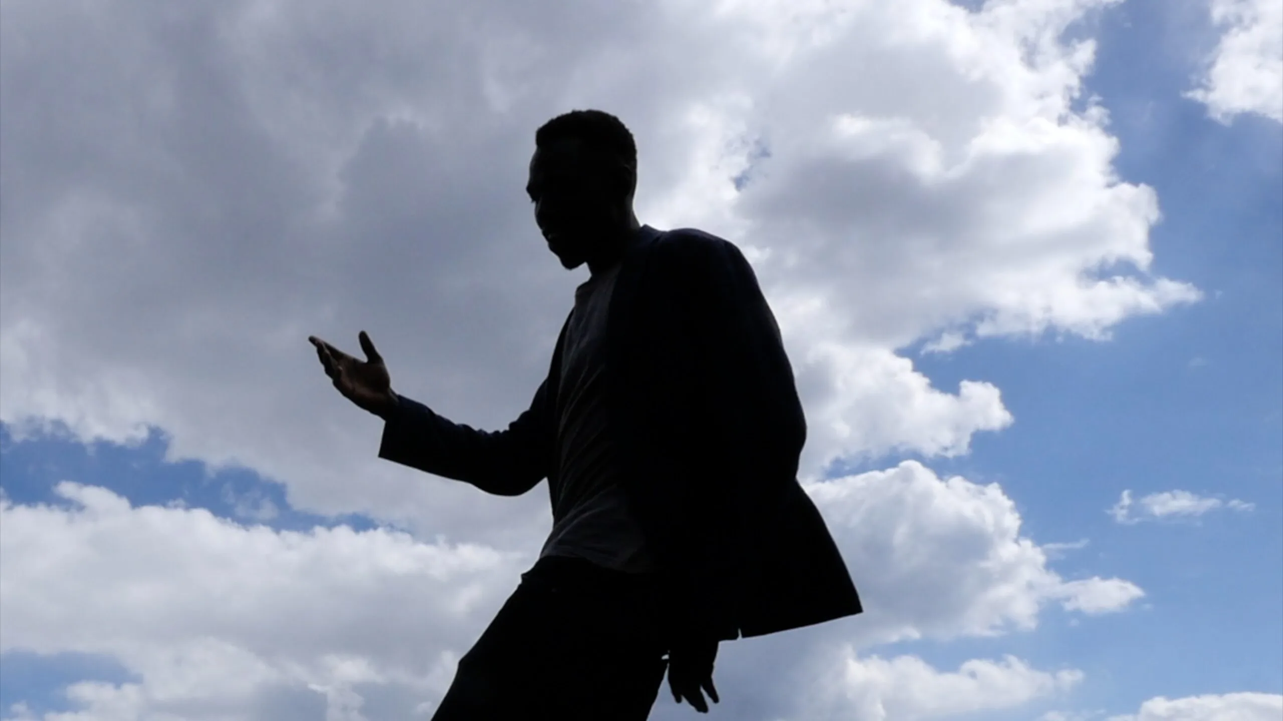 Silhouette de migrant se détachant sur le ciel