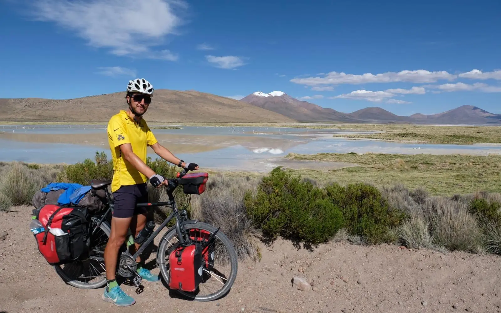 antoine de halloy et son vélo équipé de nombreuses sacoches dans un paysage sud américain