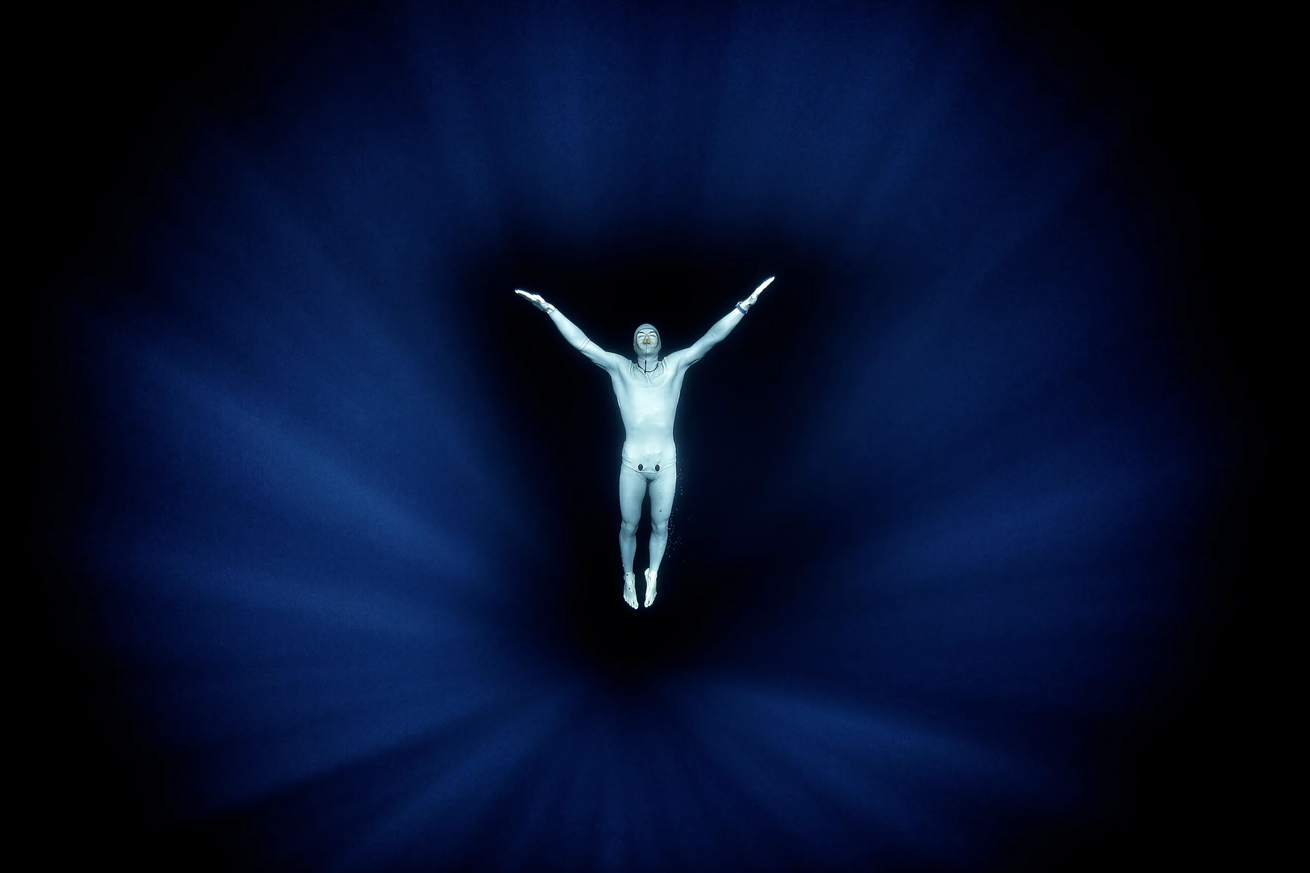 photo très esthétique de Morgan Bourc'his flottant dans le bleu très profond, en apnée, bras tendus. La pénétration des rayons donnent comme une aura.