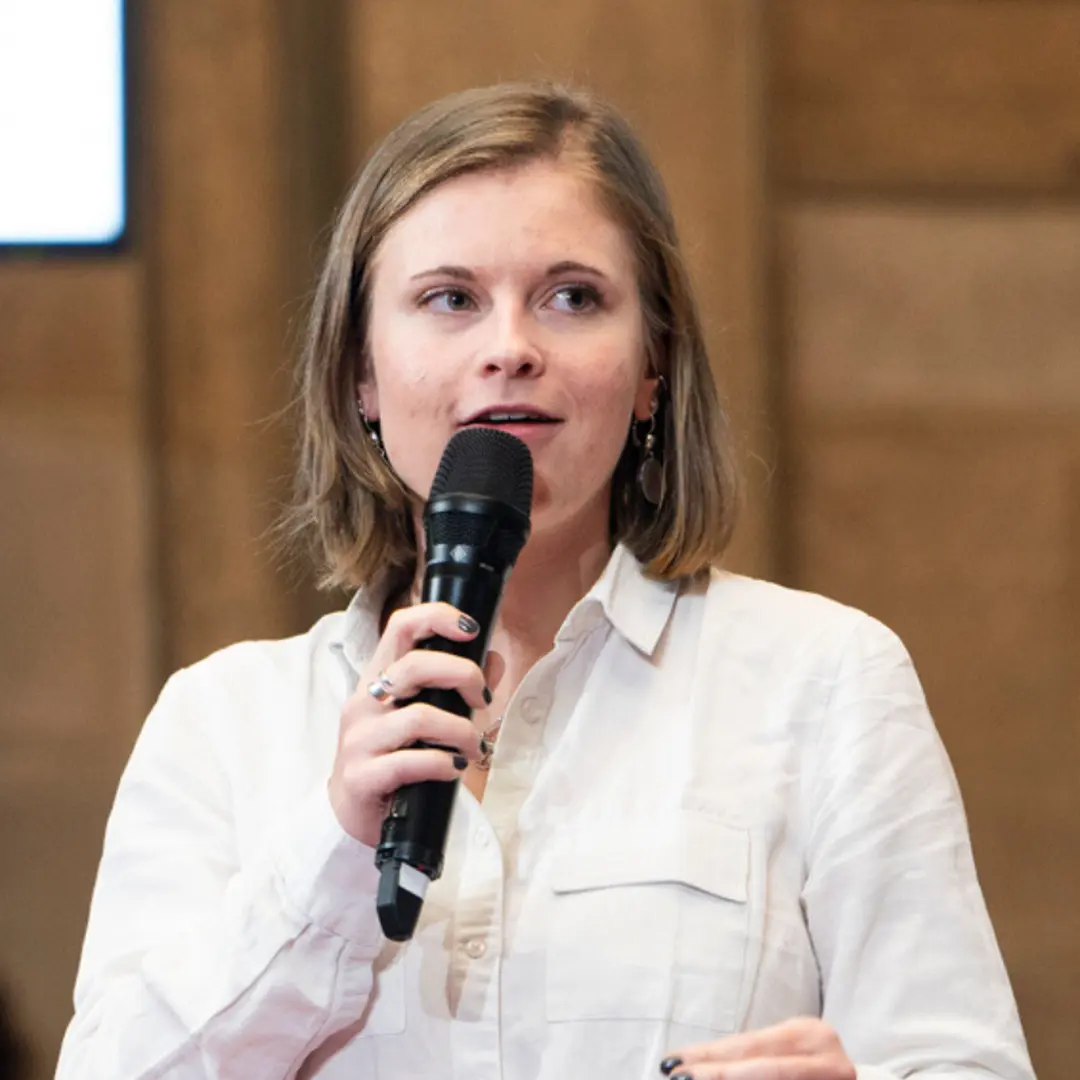 Justine micro en main donnant une conférence