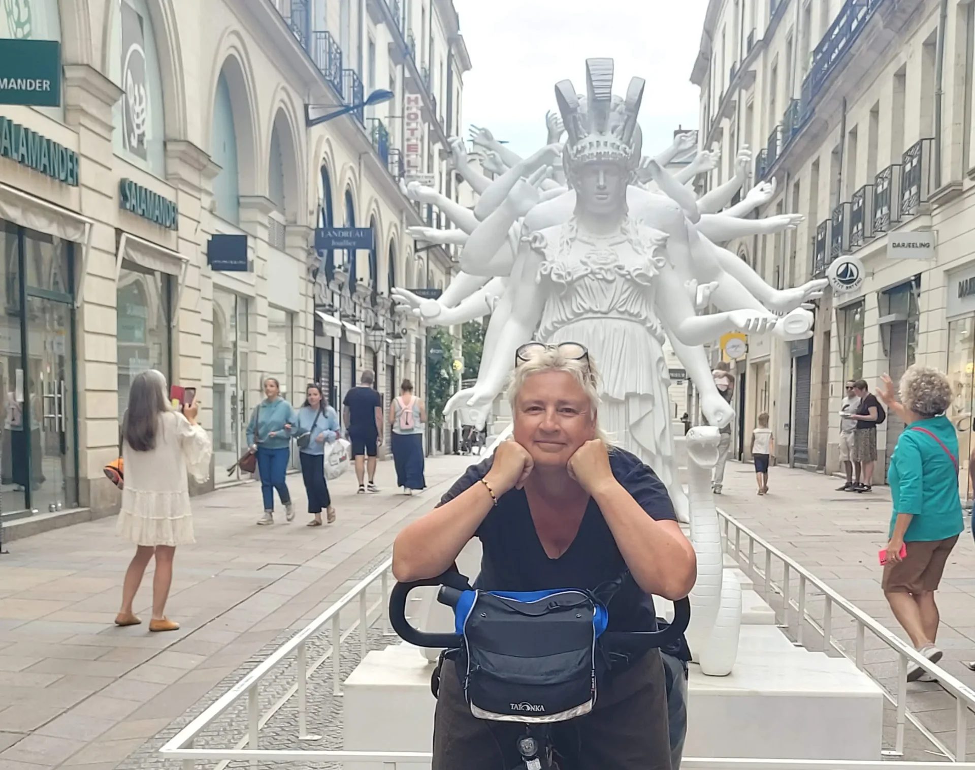 Catoche prenant la pause devant une statue, sur son vélo Marcello