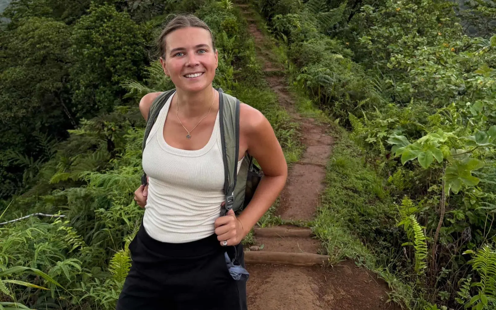 Emilie Priou rando jungle Emilie sac au dos en rando dans un paysage de collines couvertes de végétation tropicale dense
